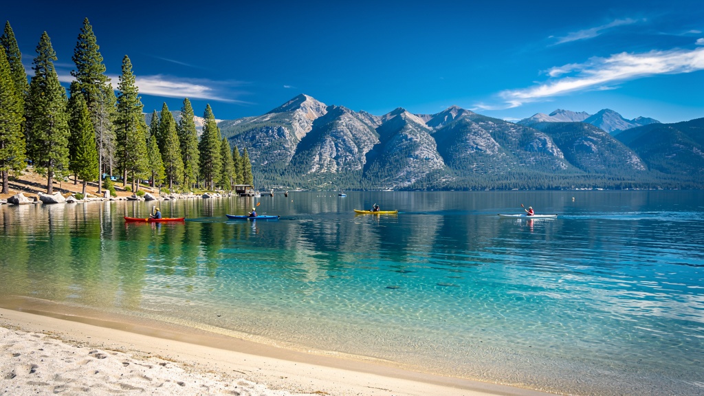 Crystal clear Lake Tahoe with pine trees and Sierra Nevada mountains