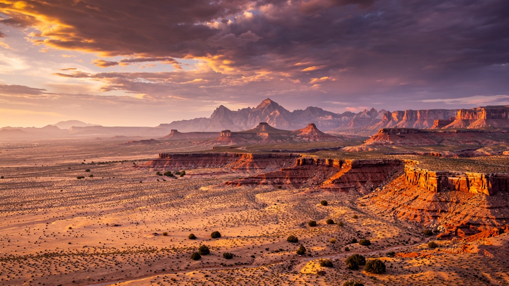 Aerial panoramic view of Nevada's vast desert landscape at golden hour with red rock formations